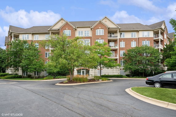 Front view of a multi-story residential building with brick exterior and balconies.