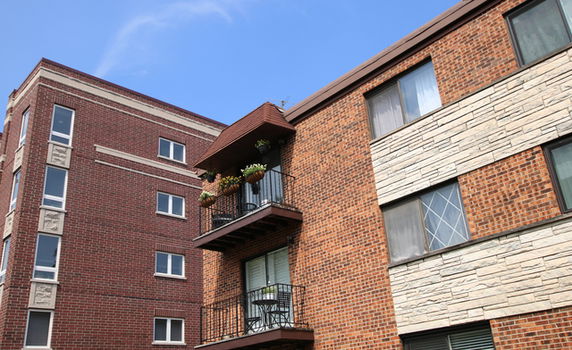 Front view of an apartment building with brick and stone facade.