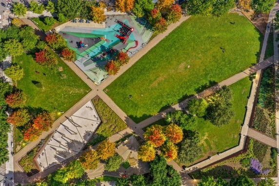 Top view of a park with grassy fields and a playground.