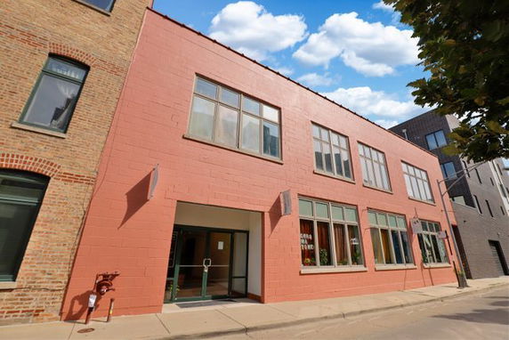 Front view of a two-story building with large windows.