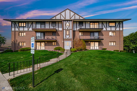 Front view of a three-story apartment building with balconies.