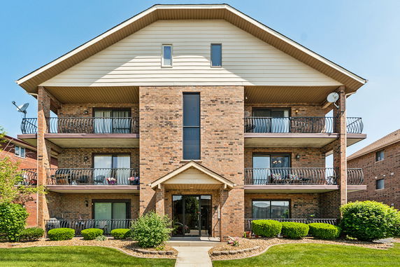 Front view of a three-story apartment building with balconies.