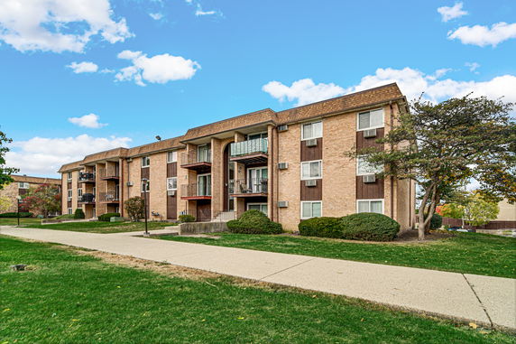 Front view of a multi-story apartment building with balconies.