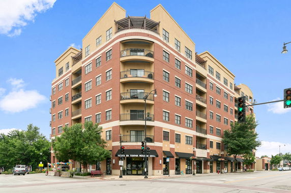 Front view of a multi-story building with brick facade and balconies.