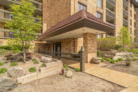 Front view of a multi-story building with brick exterior and covered entrance.