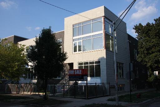 Front view of a modern two-story house for sale with large windows.