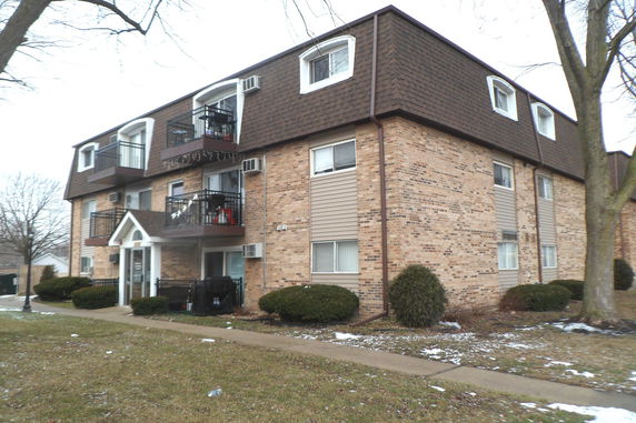 Front view of a multi-story apartment building with balconies.