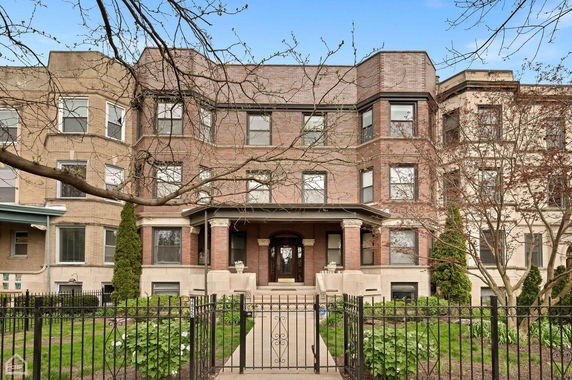 Front view of a three-story brick residential building with a central entrance.