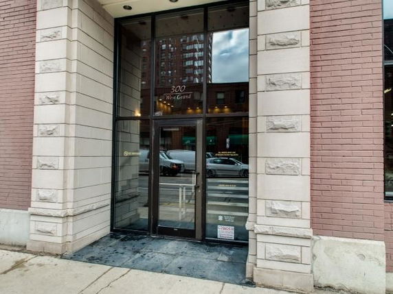 Front view of a building entrance with glass doors and brick exterior.