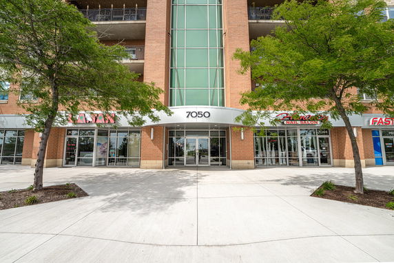 Front view of a multi-story building with commercial shops on the ground level.