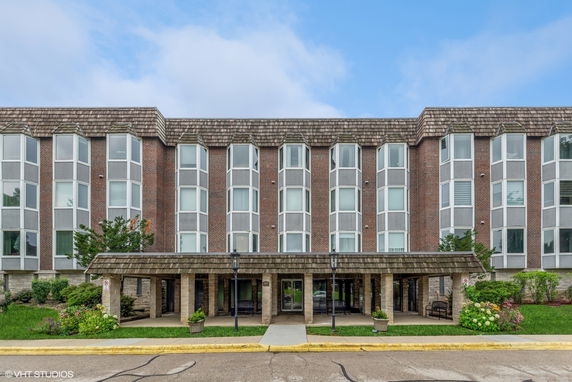 Front view of a multi-story building with large windows and a covered entrance.