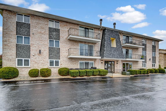 Front view of a three-story apartment building with balconies.