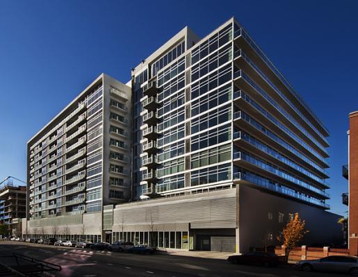 Front view of a modern multi-story building with large glass windows.
