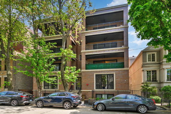 Front view of a multi-story brick building with balconies.
