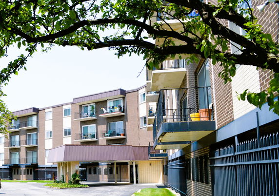 Front view of a multi-story apartment building with balconies.