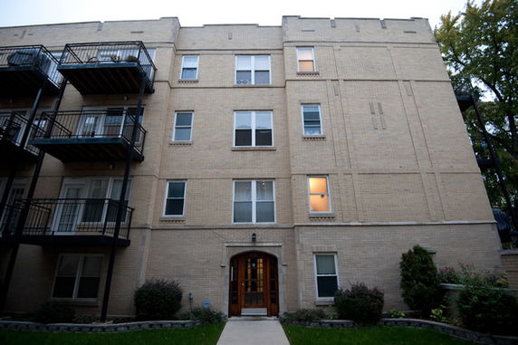 Front view of a multi-story apartment building with balconies.