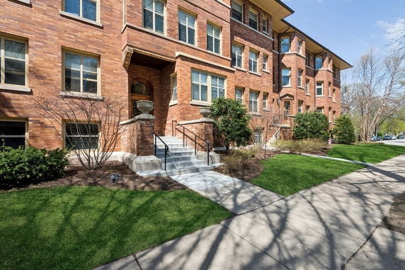 Front view of a multi-story brick building with several windows.