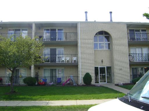 Front view of a multi-story apartment building with balconies.