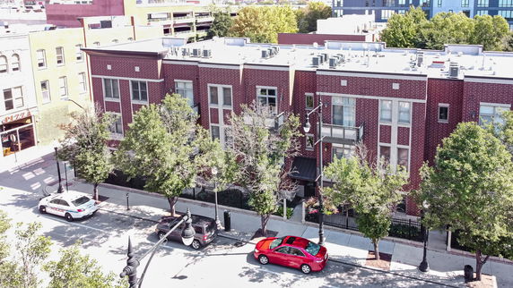 Front view of a multi-story brick building with large windows and a flat roof.