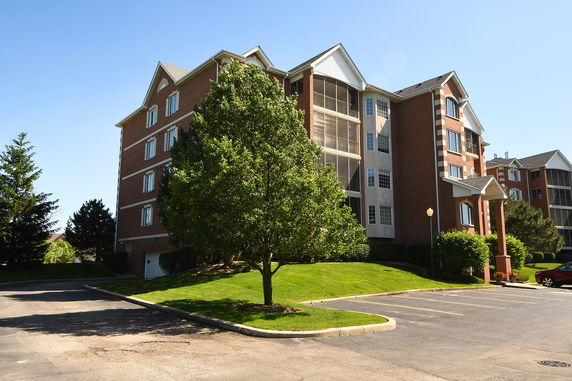 Front view of a multi-story brick apartment building with balconies.