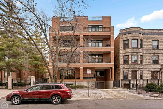 Front view of a multi-story brick building with balconies.