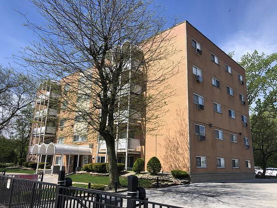 Front view of a multi-story brick apartment building.
