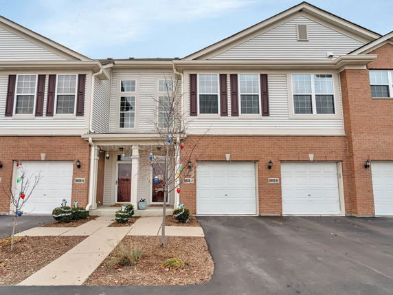 Front view of a multi-story townhouse with a double garage.