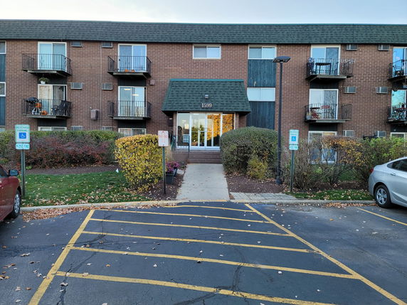 Front view of a brick apartment building with balconies.