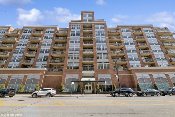 Front view of a multi-story brick building with balconies.
