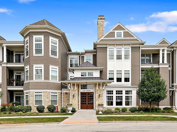 Front view of a multi-story residential building with bay windows and a central entrance.