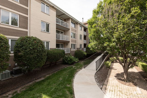 Front view of a multi-story apartment building with balconies.
