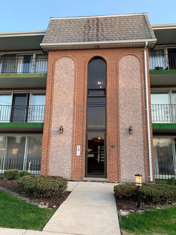 Front view of a multi-story building with a central entrance.