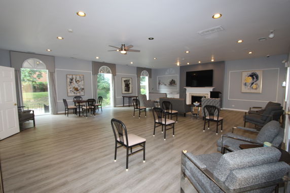 Interior view of a club house with seating arrangements and a fireplace.