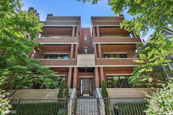 Front view of a multi-story brick building with multiple balconies.