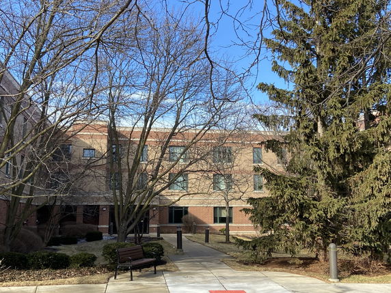 Front view of a multi-story brick building with multiple windows.