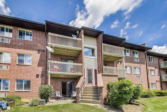 Front view of a multi-story brick building with balconies.