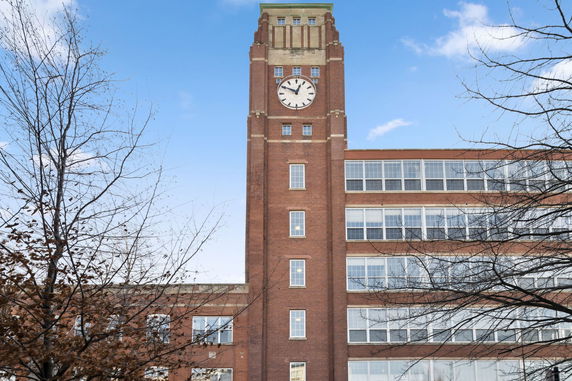 Front view of a multi-story building with a clock tower.