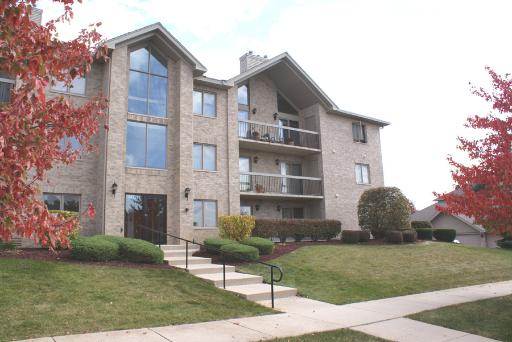 Front view of a multi-story apartment building with balconies.