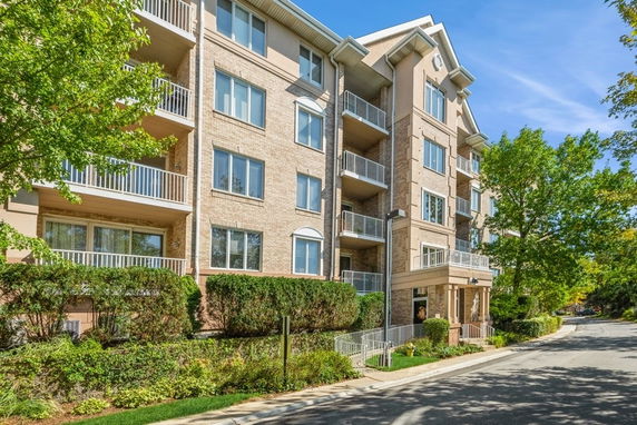 Front view of a multi-story brick apartment building with balconies.