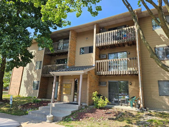 Front view of a multi-story apartment building with balconies.