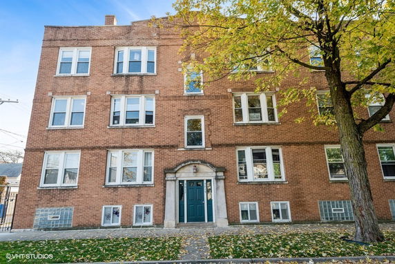 Front view of a four-story brick apartment building.