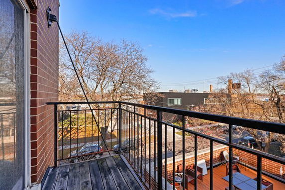 Outdoor balcony with a view of the surrounding neighborhood and trees.