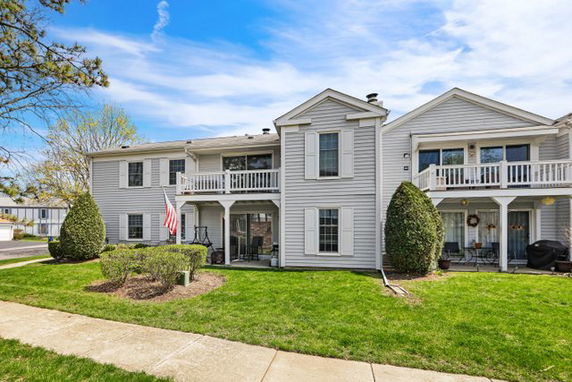 Front view of a two-story residential building with multiple balconies and a white exterior.