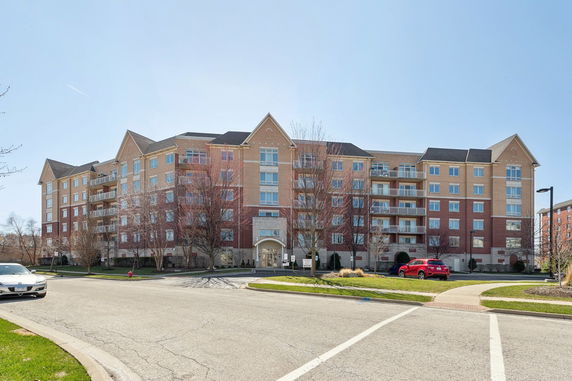 Front view of a multi-story apartment building with balconies.