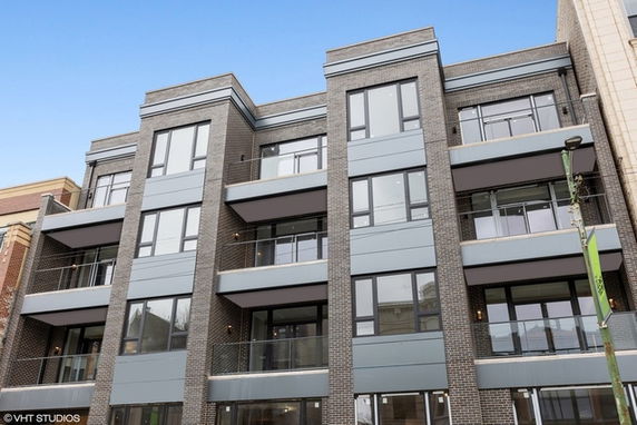 Front view of a multi-story residential building with balconies.