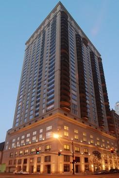 Front view of a tall multi-story building with numerous windows and balconies.