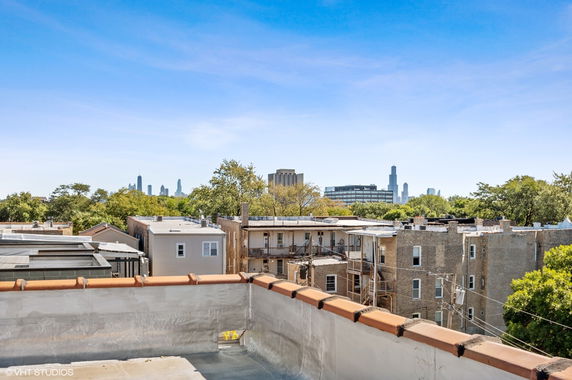 Rooftop view of buildings with distant city skyline