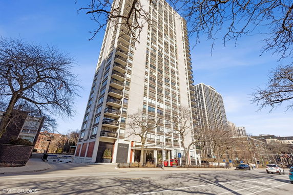 Front view of a tall apartment building with multiple balconies.