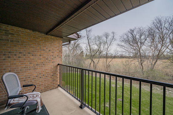View from a balcony overlooking grassy areas and trees.