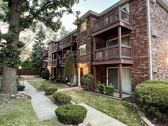 Front view of a multi-story brick building with balconies.